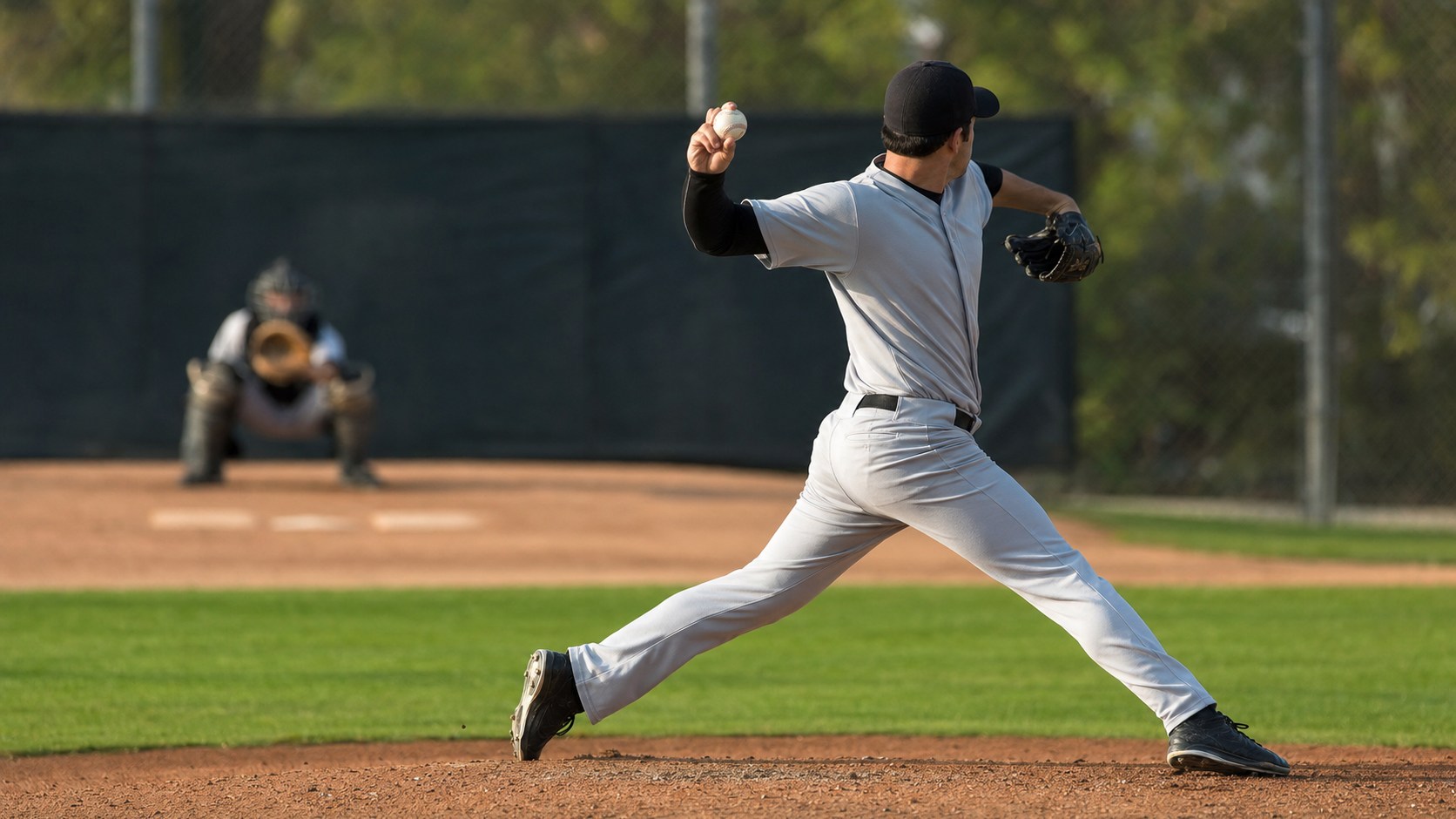 Pitcher striding down the mound during a full pitching delivery