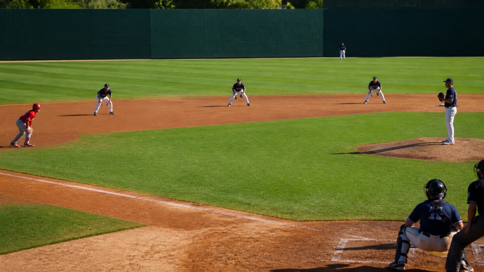 Baseball infielders positioned close to home plate during a pressure situation with a runner on third